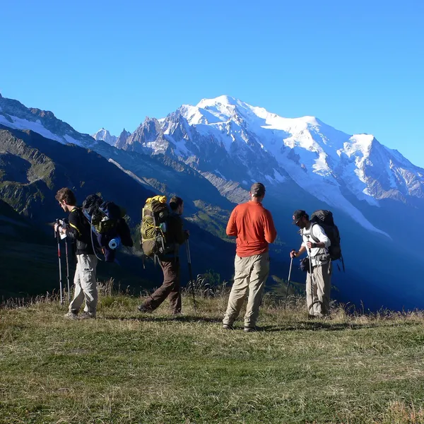 Quatre randonneurs sac au dos au col de Balme, face au massif du Mont-Blanc