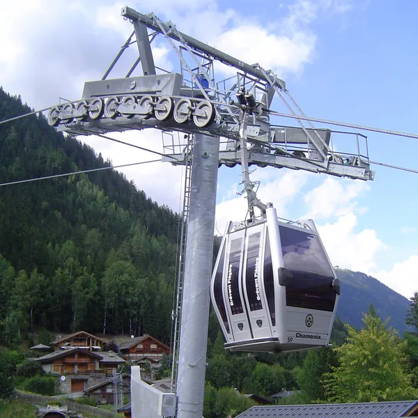 Une cabine de la télécabine de la Flégère au départ des Praz, chalets et forêt en contrebas